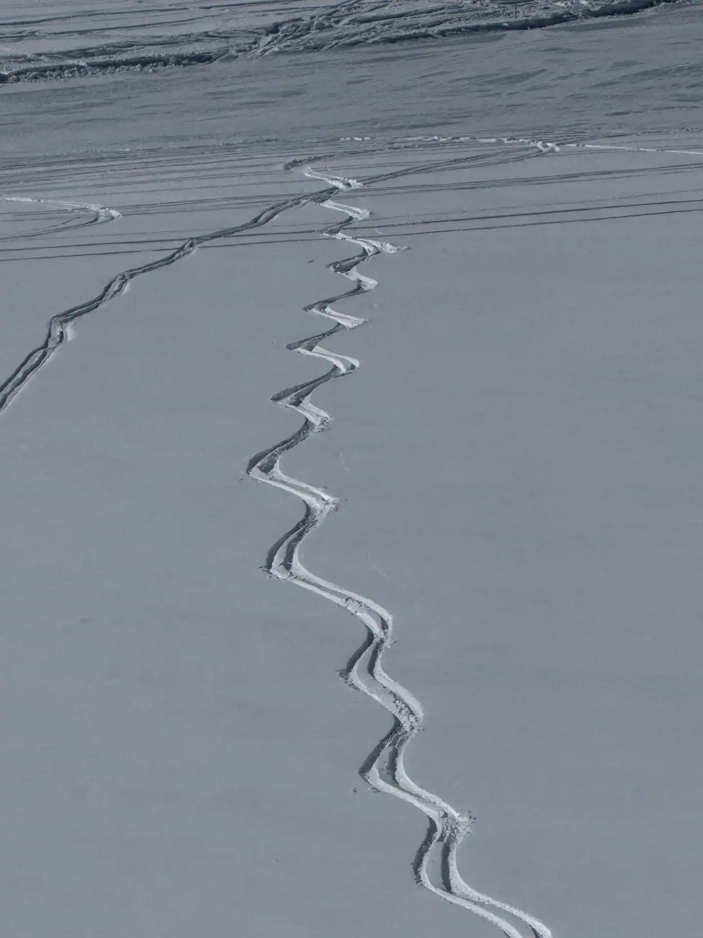 Fresh signature ski tracks carving down untouched powder at La Parva