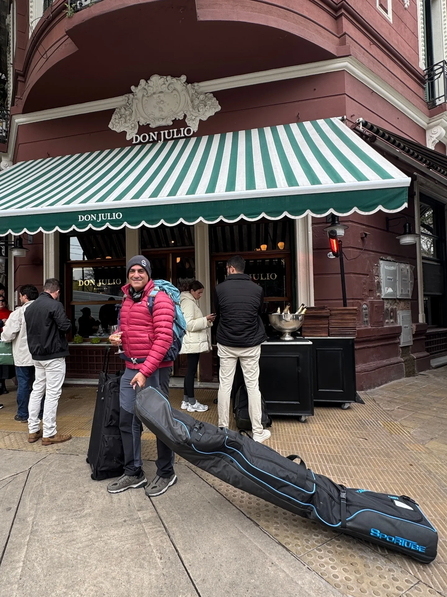 Cogo standing in front of Don Julio steakhouse in Buenos Aires with a ski bag before flying to Bariloche
