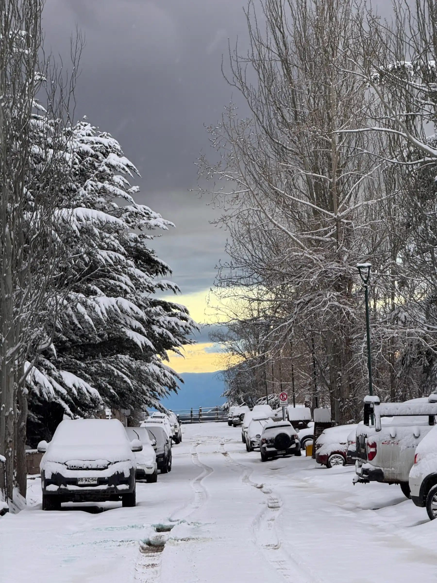 Snow-covered street with parked cars after a fresh storm in the Andes