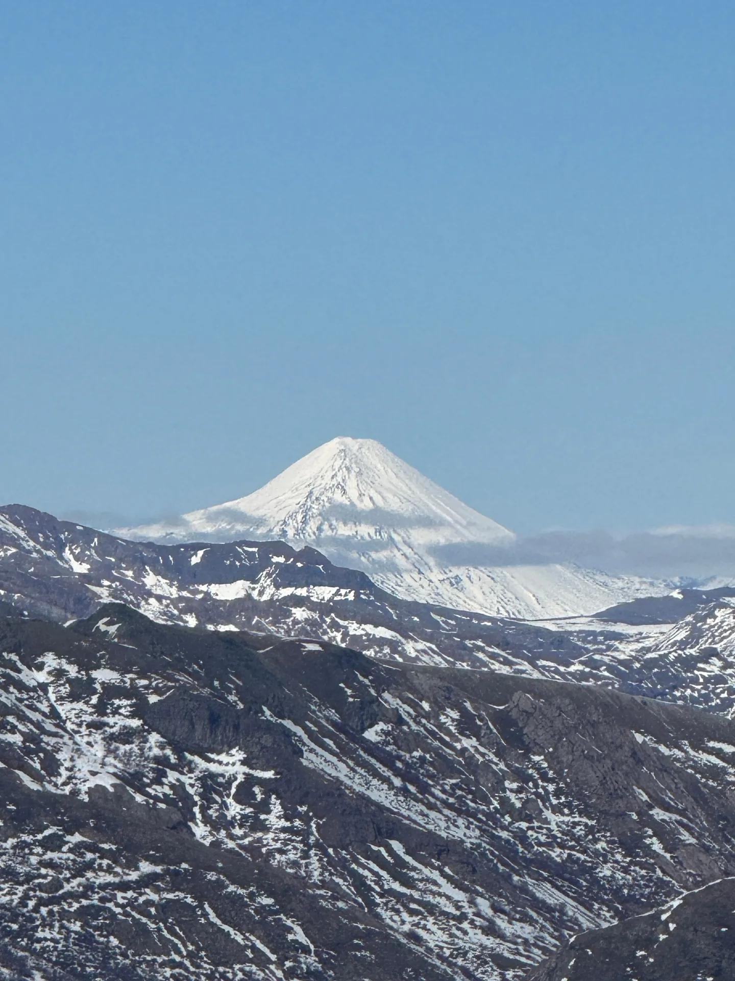 Snow-covered conical Chilean volcano rising above the Andes, a classic ski touring summit in the Araucanía region