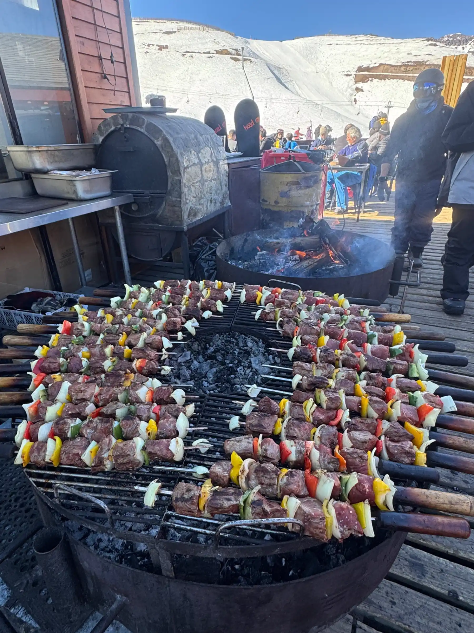 Anticuchos beef skewers grilling over fire at Valle Nevado mountain restaurant