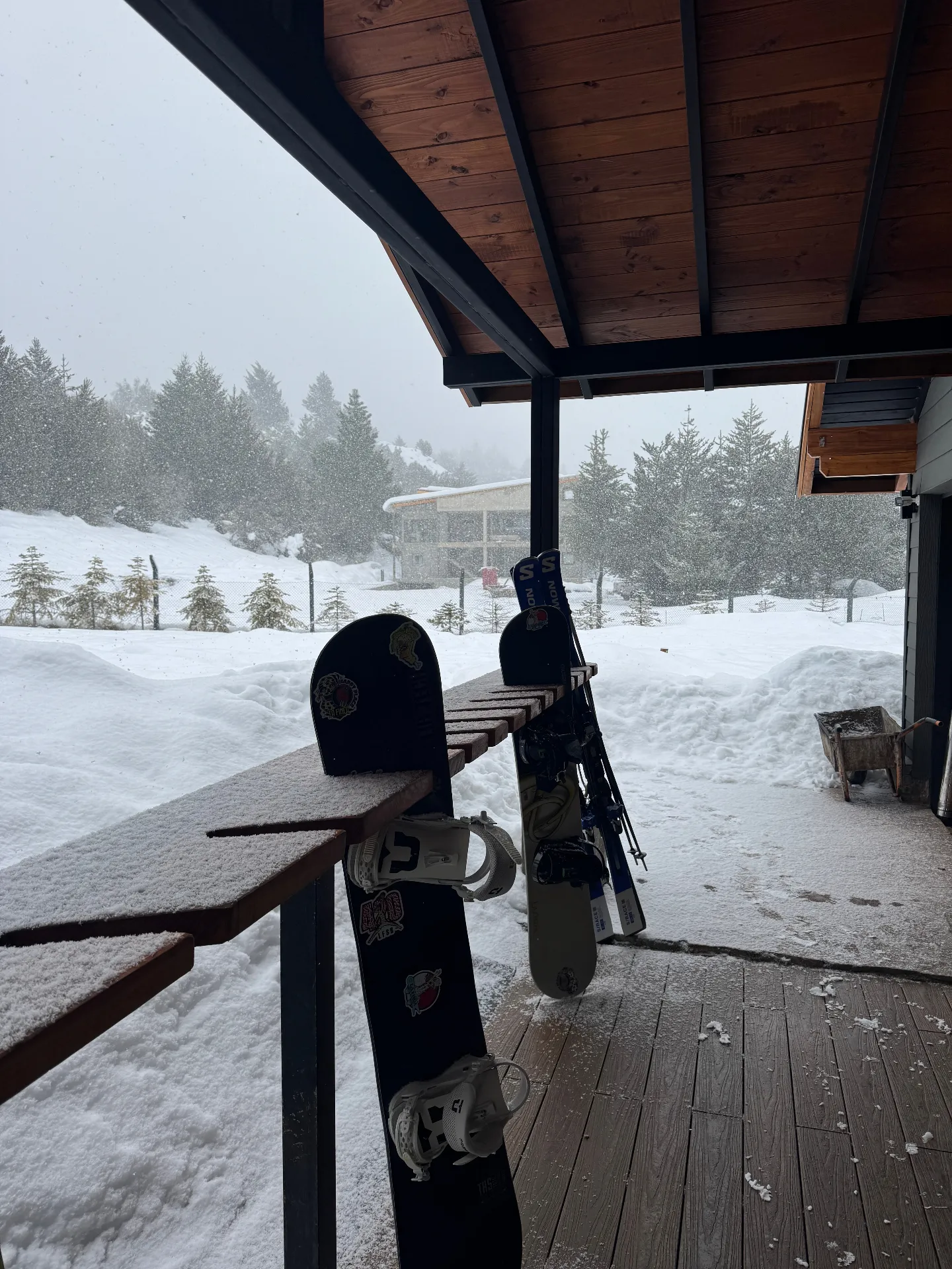 Fresh snowfall on a Bariloche lodge deck with skis