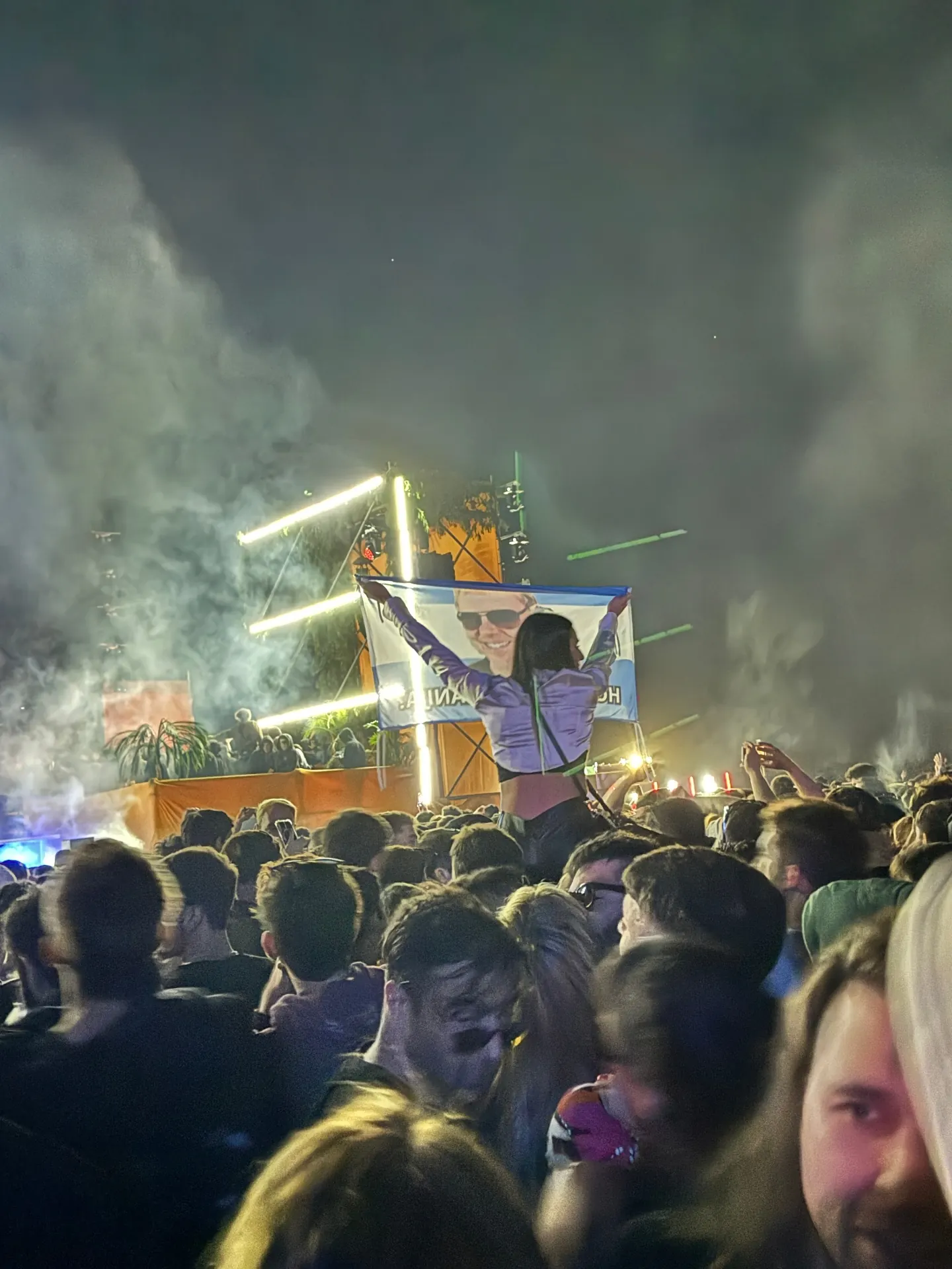 Argentina outdoor night party crowd with stage lights and Argentine flag