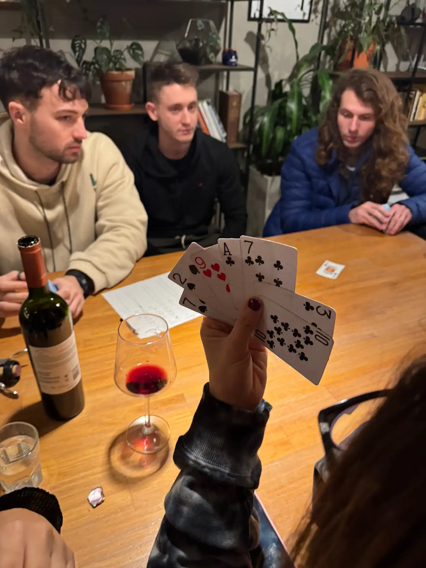 Friends playing cards with red wine after skiing in Ushuaia