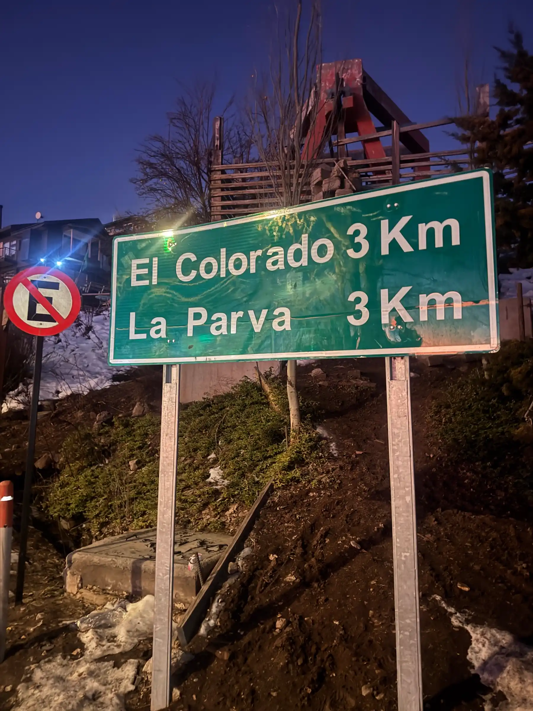 Road sign for El Colorado and La Parva on the mountain access road at dusk