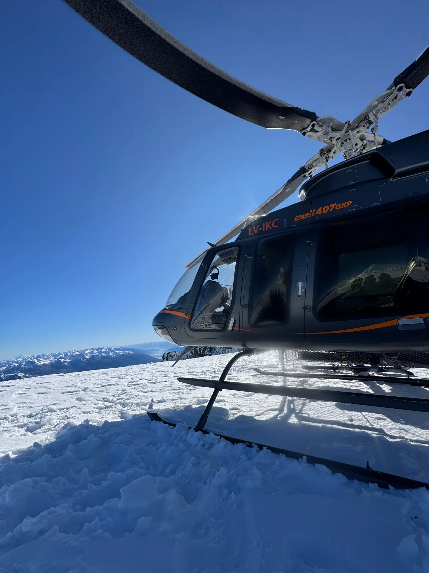 Helicopter on a snow-covered summit landing pad in the Patagonian Andes